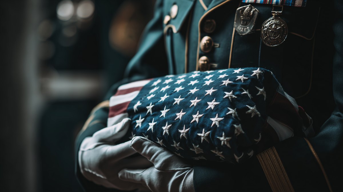 A person in a soft blue sweater holding a single white rose, symbolizing remembrance supported by Summit, NJ funeral home and cremations.